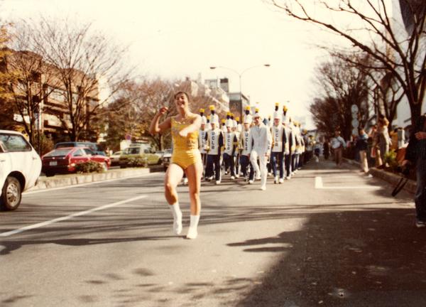 Dancer leading marching band on street
