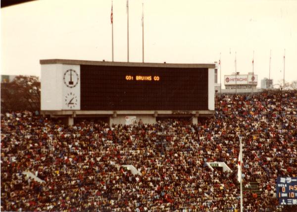 View of scoreboard displaying "Go! Bruins Go" with large crown gathered in stadium