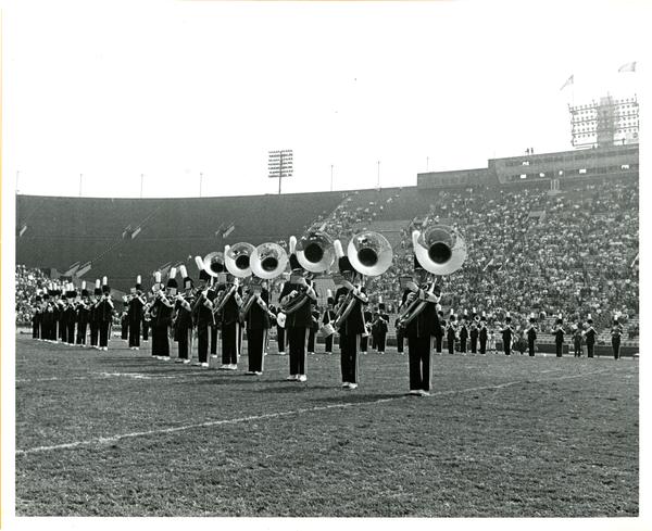 Marching band brass players performing in football stadium