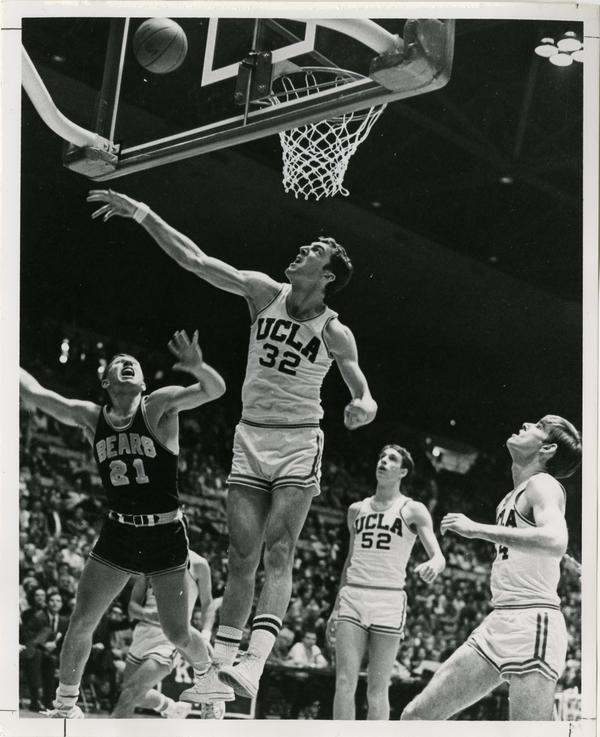 Both Steve Patterson (32) and a member of the Cal Bears give the basketball a disapproving look.