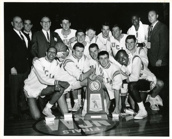 Team portrait on court with NCAA trophy, 1965