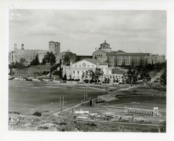 Students on the athletic field with Student Activities Center, Royce Hall and Powell Library in the background