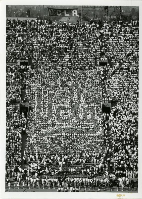 Students holding up cards spelling out UCLA at the football game, ca. 1955