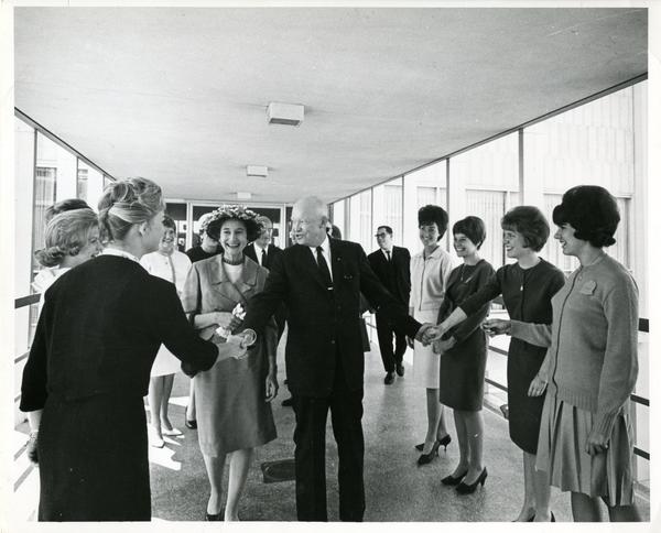 Former President Dwight Eisenhower being greeted by people in hallway, Charter Day 1963