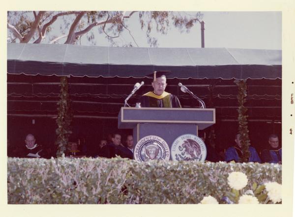 UCLA Chancellor Murphy speaks at podium on Charter Day 1964