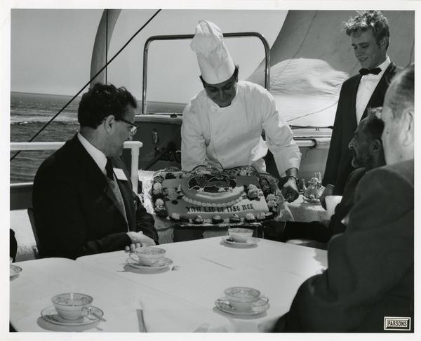 Chef presenting cake to Emperor Haile Selassie of Ethiopia upon Motor Yacht Argo, April 25, 1967