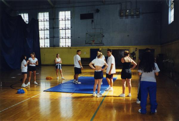 Cheerleaders gathered around in the gym