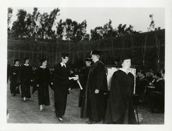 Graduates receiving their diplomas at Commencement, circa 1940's