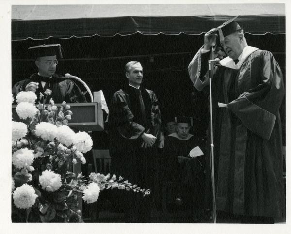 Mohammad Reza Pahlavi, the Shah of Iran, receiving his honorary degree from President Clark Kern and Regent Edwin Pauley at Commencement, 1964