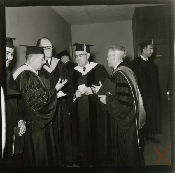 Contact print of faculty and staff gathered around after Mid-Year Commencement, January 28, 1964