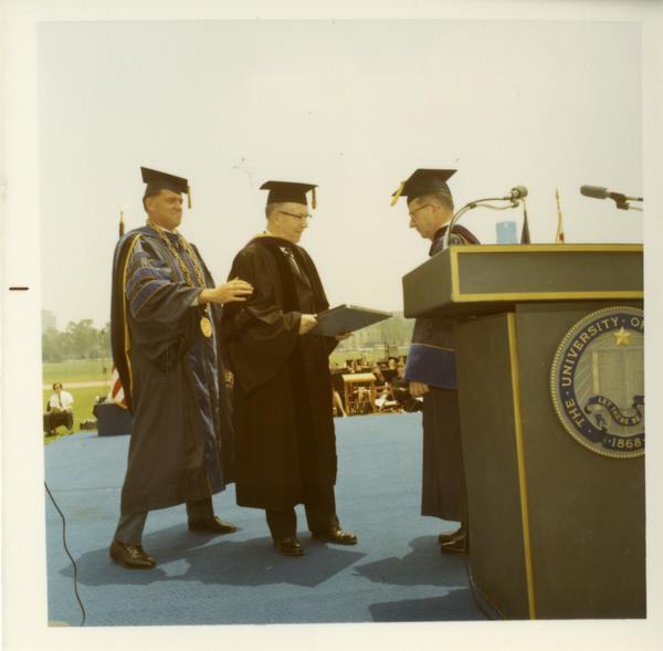 Honorary degree recipient shaking hands with unidentified man on stage at Commencement, June 17, 1970
