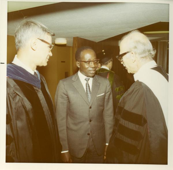 Commencement participants talking with an unknown man at Commencement, 1971