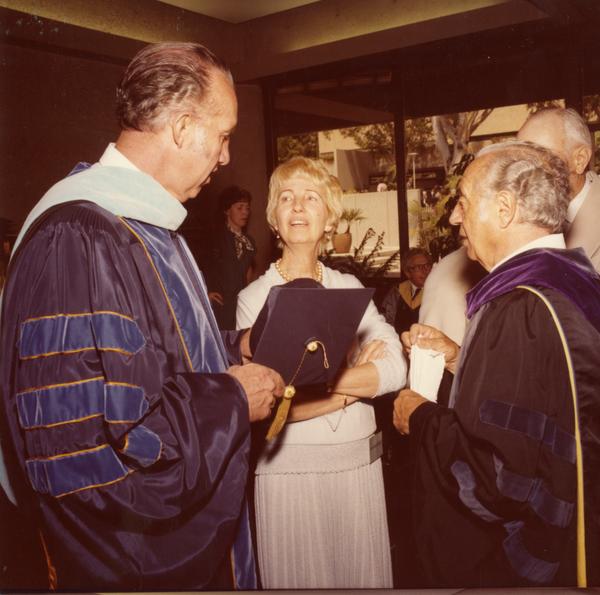Elwin Svenson and Charles Speroni talking with a woman at commencement, June 1979