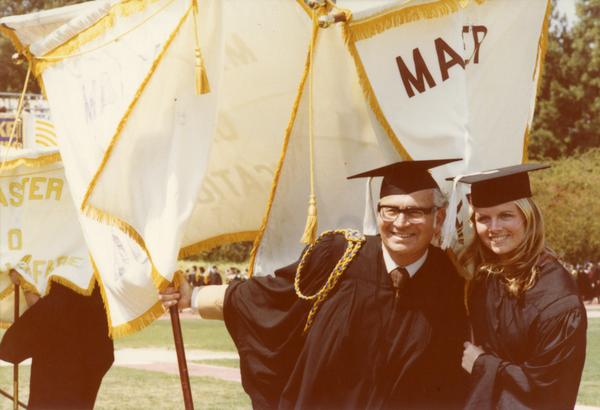Member of the platform party poses for a picture with a graduate at commencement, June 1979