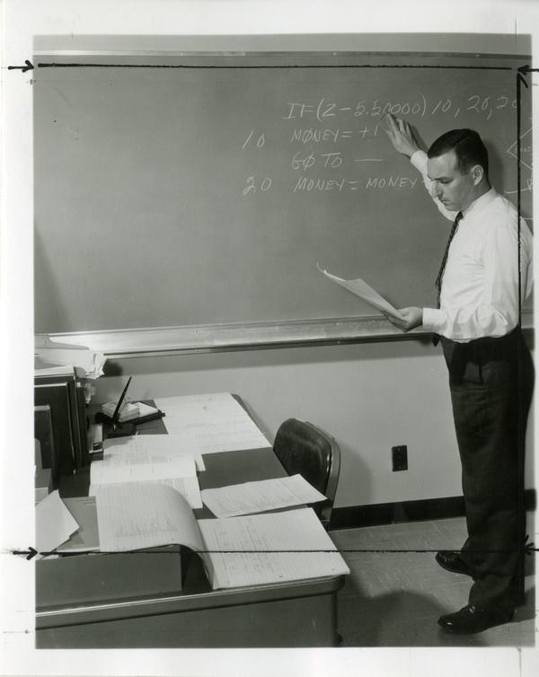 Man reviews notes on the chalkboard at the Western Data Processing Center