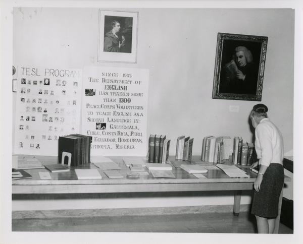 Woman looks at books and papers set out for display in the English Reading Room for an UCLA Open House