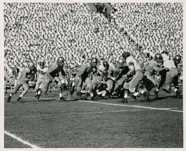 Football players on the field during USC-UCLA game, ca. 1954