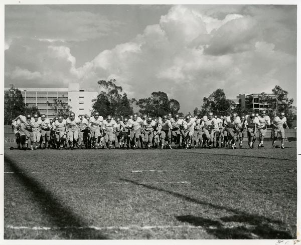 UCLA football team lined up and running, 1963