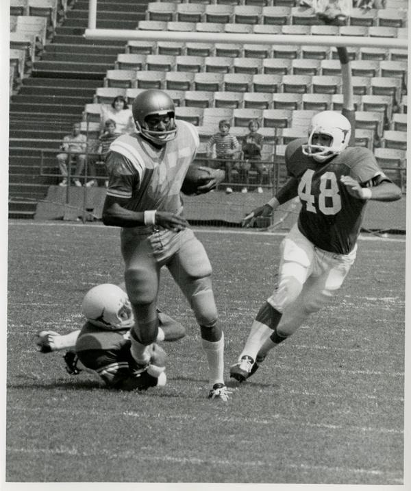 UCLA flankerback Reggie Echols surviving an attempted tackle during a football game, September 18, 1971