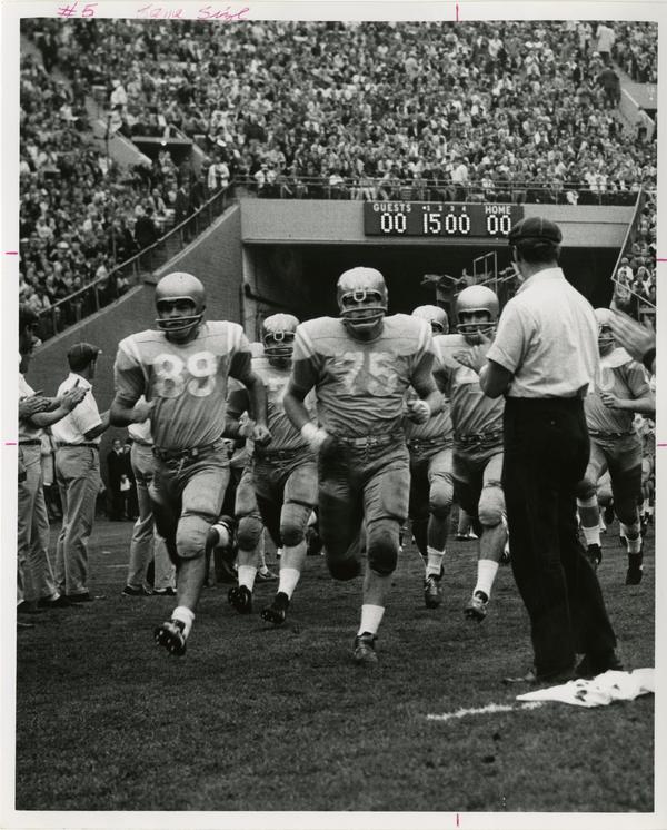 UCLA football player John Richardson running with the rest of the team onto the field for a game