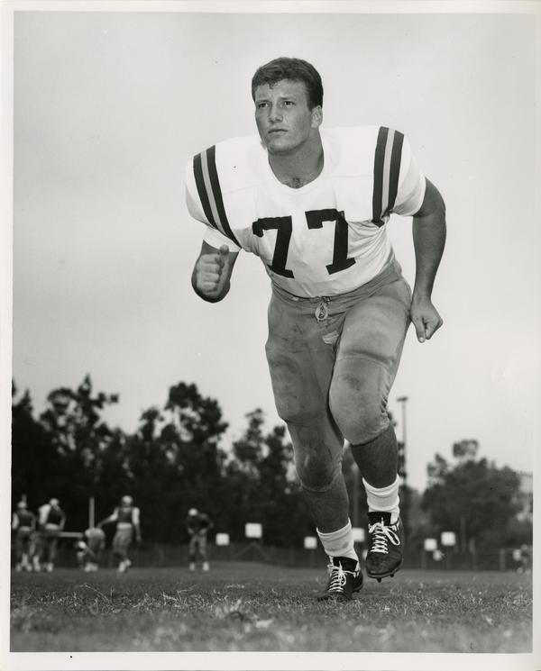UCLA right tackle Larry Sleagle running on the field, 1966