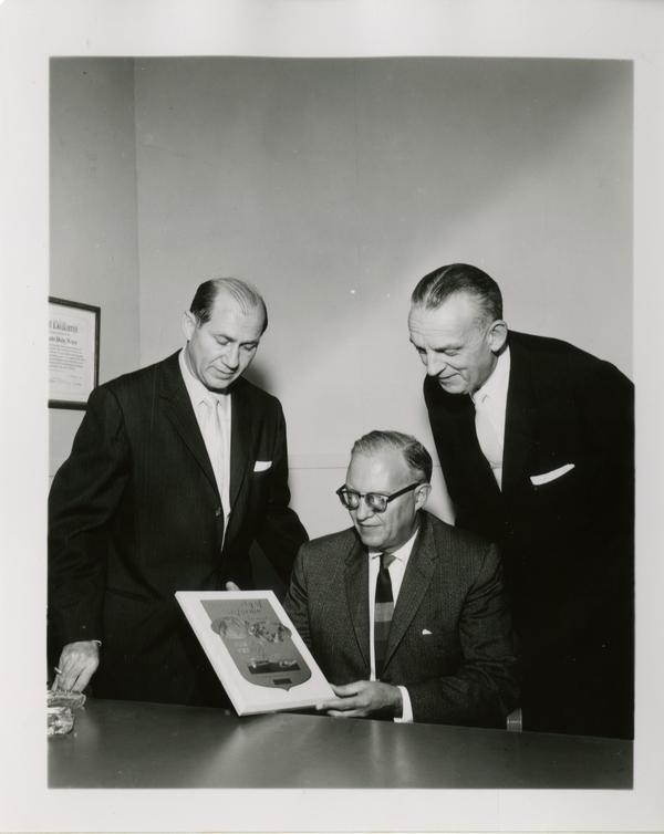 Three men standing around the 1958 Foreign Press Award