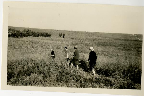 Four attendees of the campus dedication walking through a field, 1926