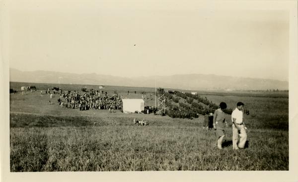 Two attendees walk away from the stage area of the dedication of the new campus, October 1926