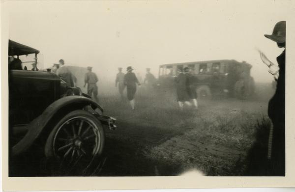 Dedication attendees walking through the dust caused by cars arriving to the dedication area, October 1926