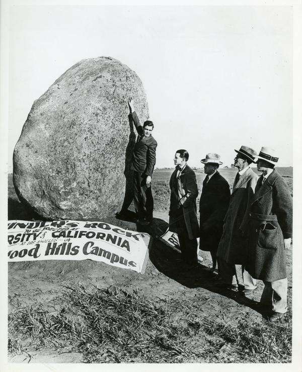 Bob Huff, a student, Regent Edward A. Dickson, and Earle Hedrick (later UCLA Provost at this time a math professor at UCLA) standing next to the Founder's Rock, which is in a vertical position