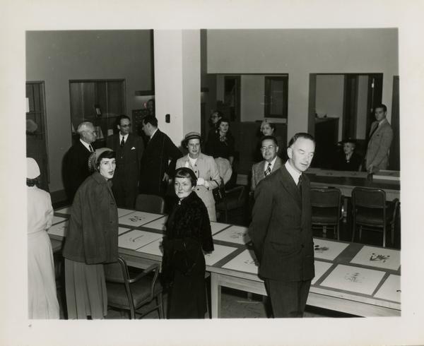Members of Friends of the UCLA Library looking at large prints