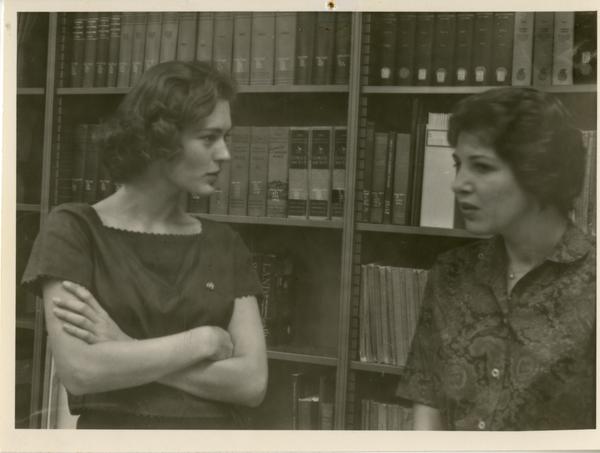 Women, presumably of the geography department, talking in the library