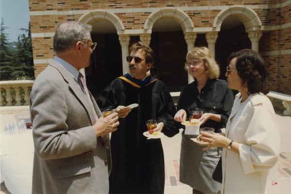 Chancellor Young, Edward Alpers, Carol Hartsog and Bea Mandel gather together outside of Royce Hall after PhD Hooding Ceremony, June 1988