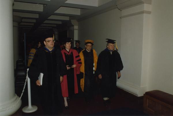 Malcolm, Wally Goldschmidt and others walk down hall during PhD Hooding Ceremony, June 1988