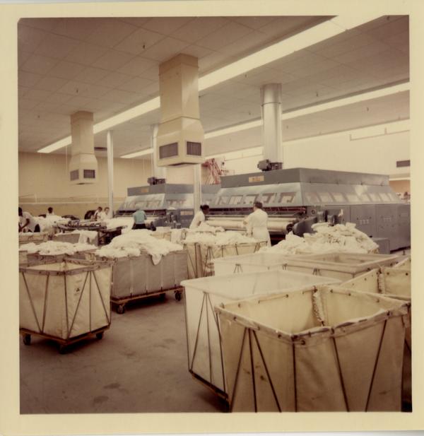 View of laundry workers at stations in UCLA Laundry Facility