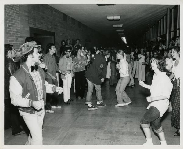 Students dancing 1950s Sock Hop in hallway of Law School, ca. 1980