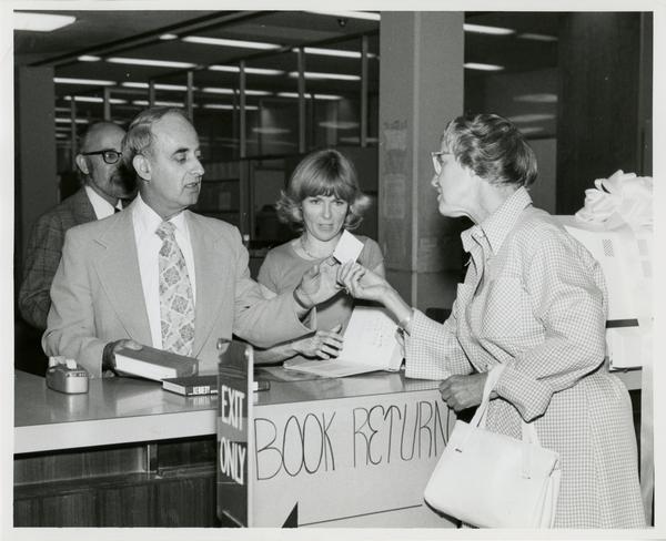 Page Ackerman hands card to Russell Shank while Jim Cox and Linda Fierro stand in background