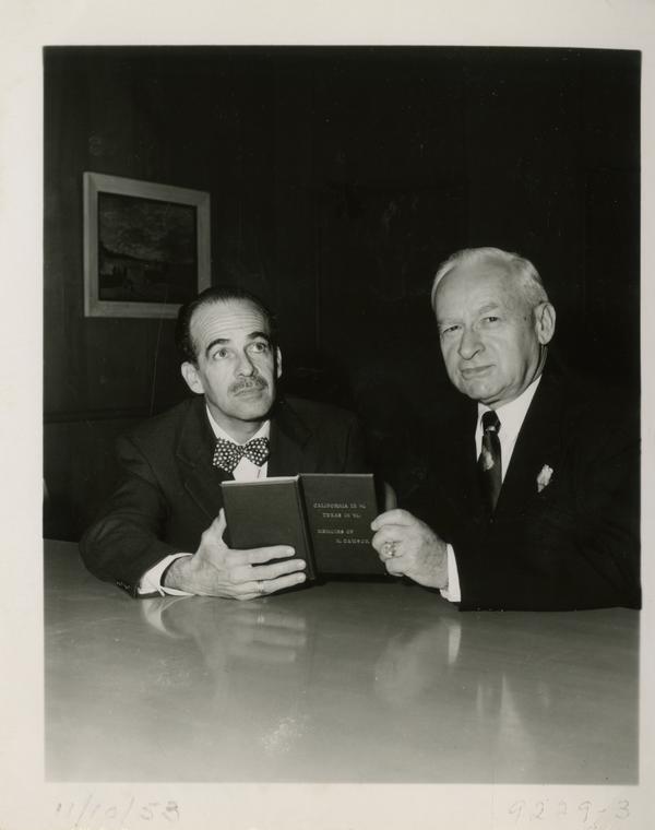 Dwight L. Clarke and Lawrence Clark Powell holding one millionth volume, November 10, 1953