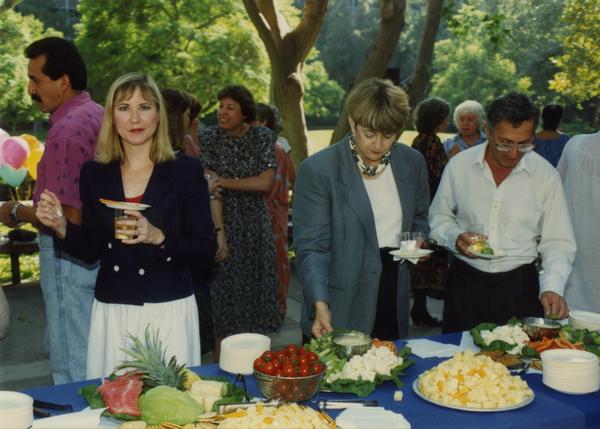 Library staff members enjoying snacks and refreshments at retirees party, ca. 1991