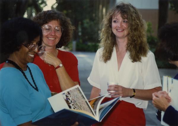 Library staff looking through a book, ca. 1991