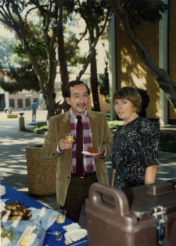 Library staff standing in front of the food table, mid-conversation, ca. 1991