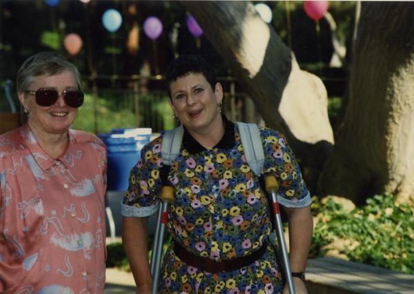 Two library staff members smile for the camera at a staff event, ca. 1991