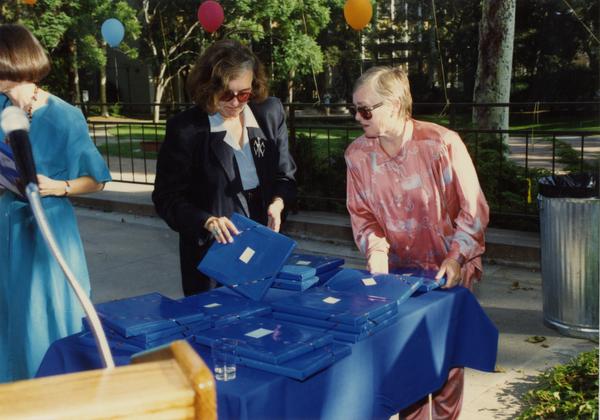 Library staff workers pass out wrapped gifts at a staff retirement party, 1991