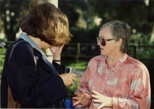 Library staff workers talk to each other at a staff retirement party, 1991