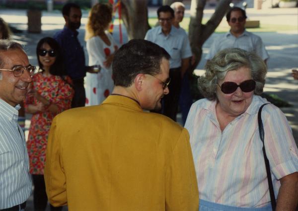 Library staff laugh and talk to each other at a staff retirement party, 1991