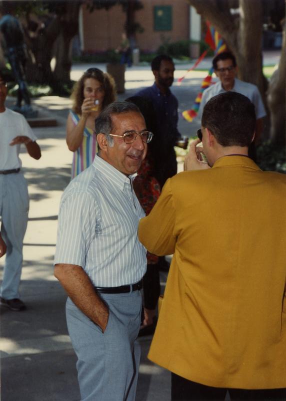 Candid photo of a library staff talking with another staff member at the staff retirement party, 1991