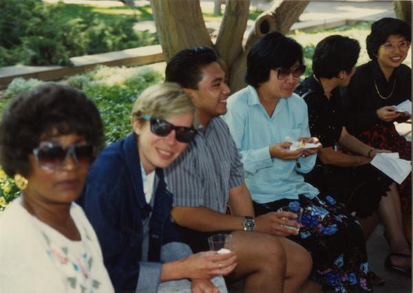 Library staff sitting, eating at the staff retirement party, 1991