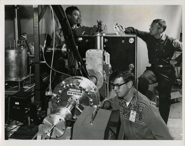 James L. Tuck, left, head of the Sherwood Project at Los Alamos, John Marshall, back right, John E. Osher, foreground, working on the new entropy-trapping equipment at the Los Alamos Scientific Lab, New Mexico