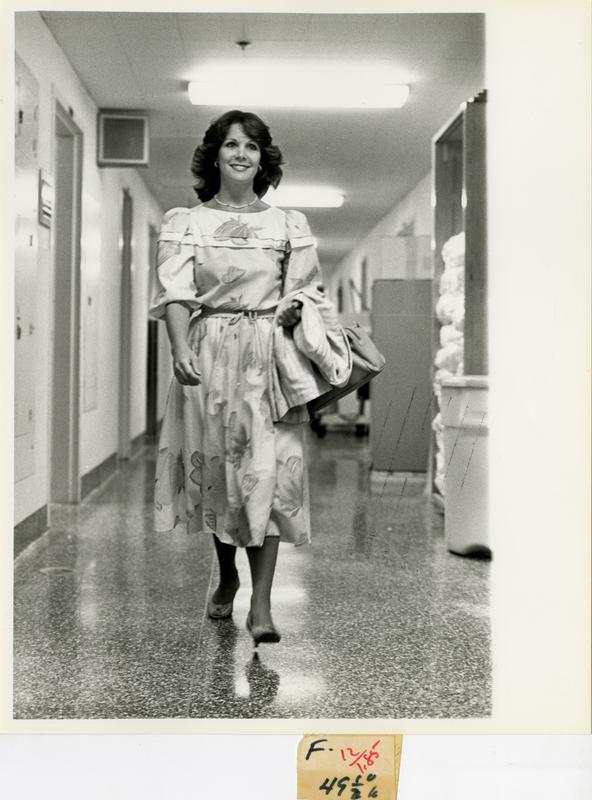 Nurse out of uniform walking down hall of facility