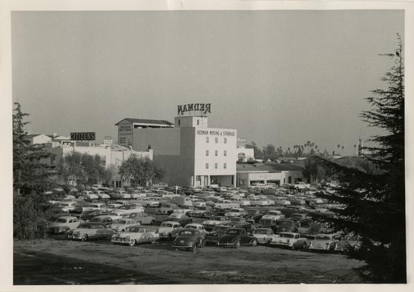 Cars parked on a dirt lot with Redman Moving & Storage sign in background